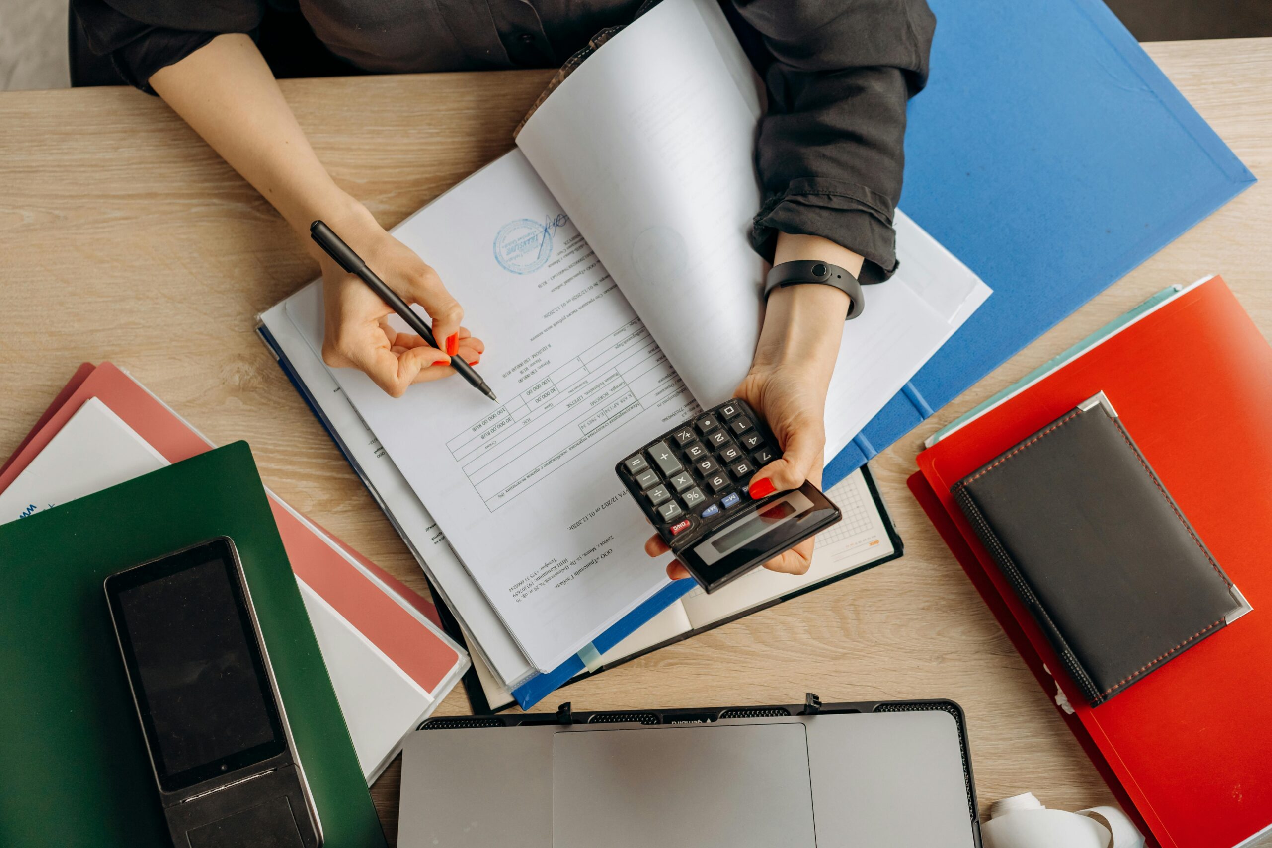 Person reviewing financial documents with a calculator for personal loan comparison
